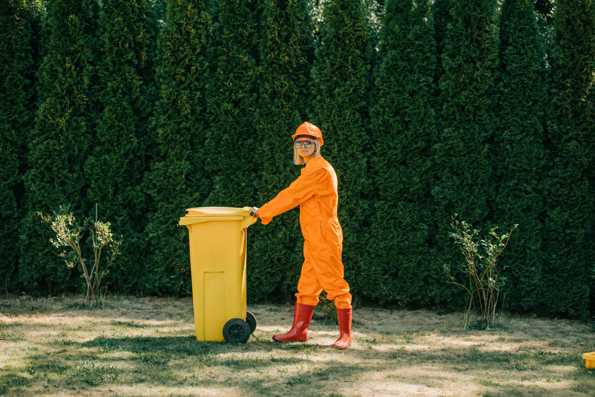 woman in orange suit, hardhat, and protective goggles with yellow spill kit